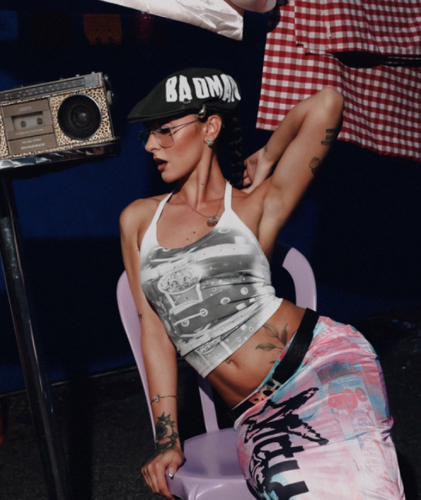 Artist in a crop top against a red wall